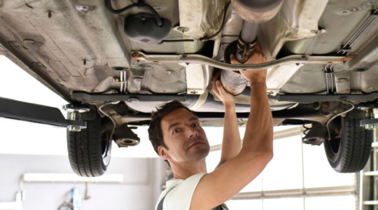 Mechanic installing a catalytic converter 1100x550
